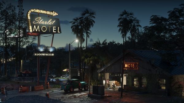 The neon sign of the Starlet Motel glowing at dusk among palm trees